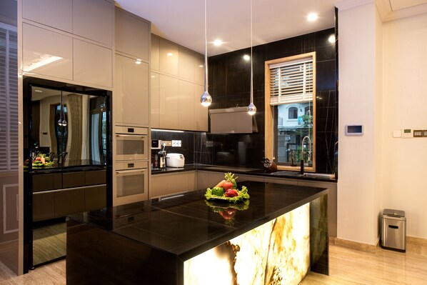 A modern kitchen with a central island, built-in appliances, and a view of the city. - Icity Lakeview Saigon Villa (Ho Chi Minh City)