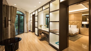 Una habitación de hotel moderna con una cama grande, un escritorio y vistas a zonas verdes.