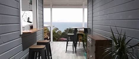 A modern interior with a wooden floor, a central seating area, and a view of the outdoors.