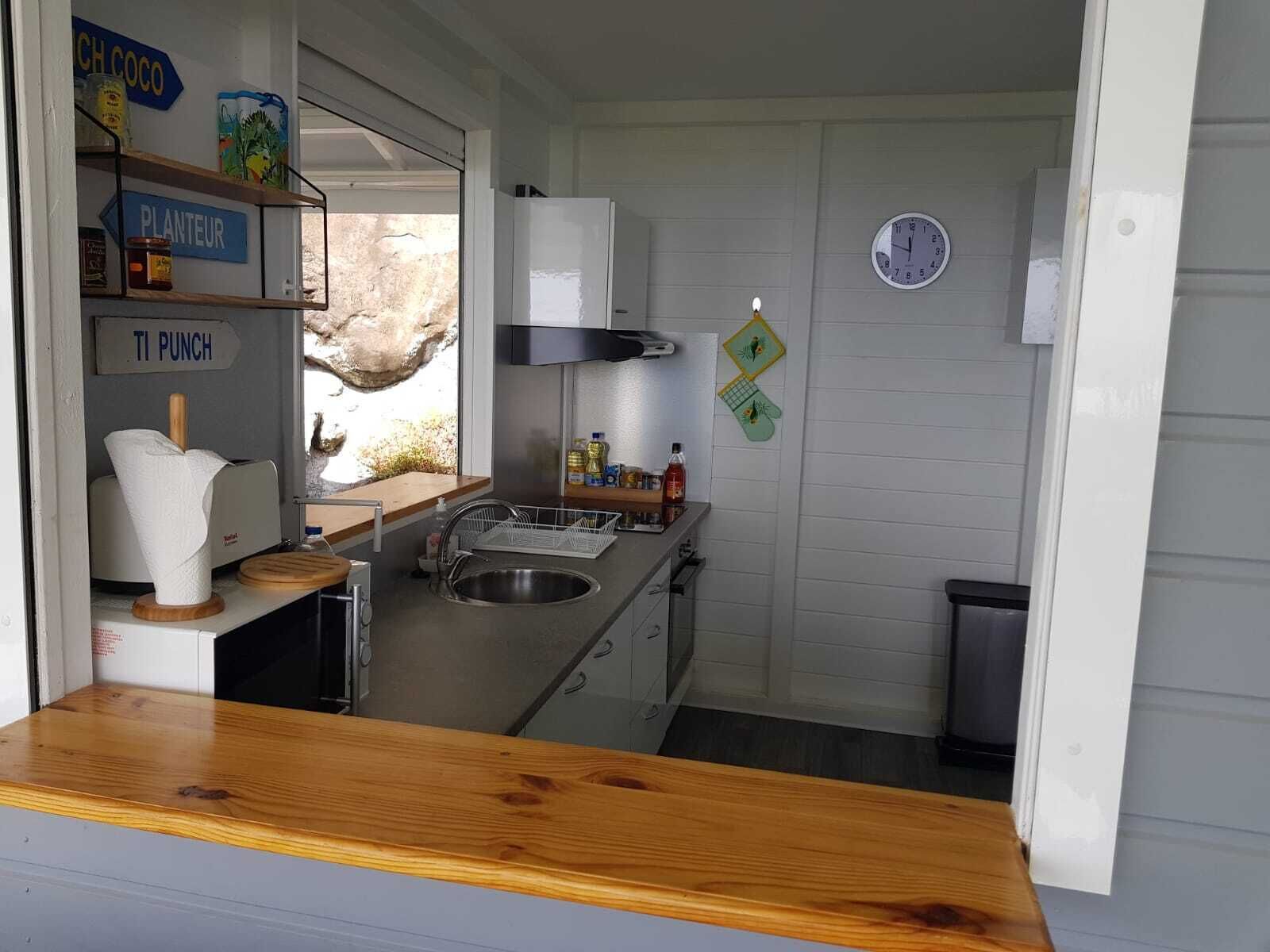 A compact kitchen with a sink, stove, and wooden countertop.