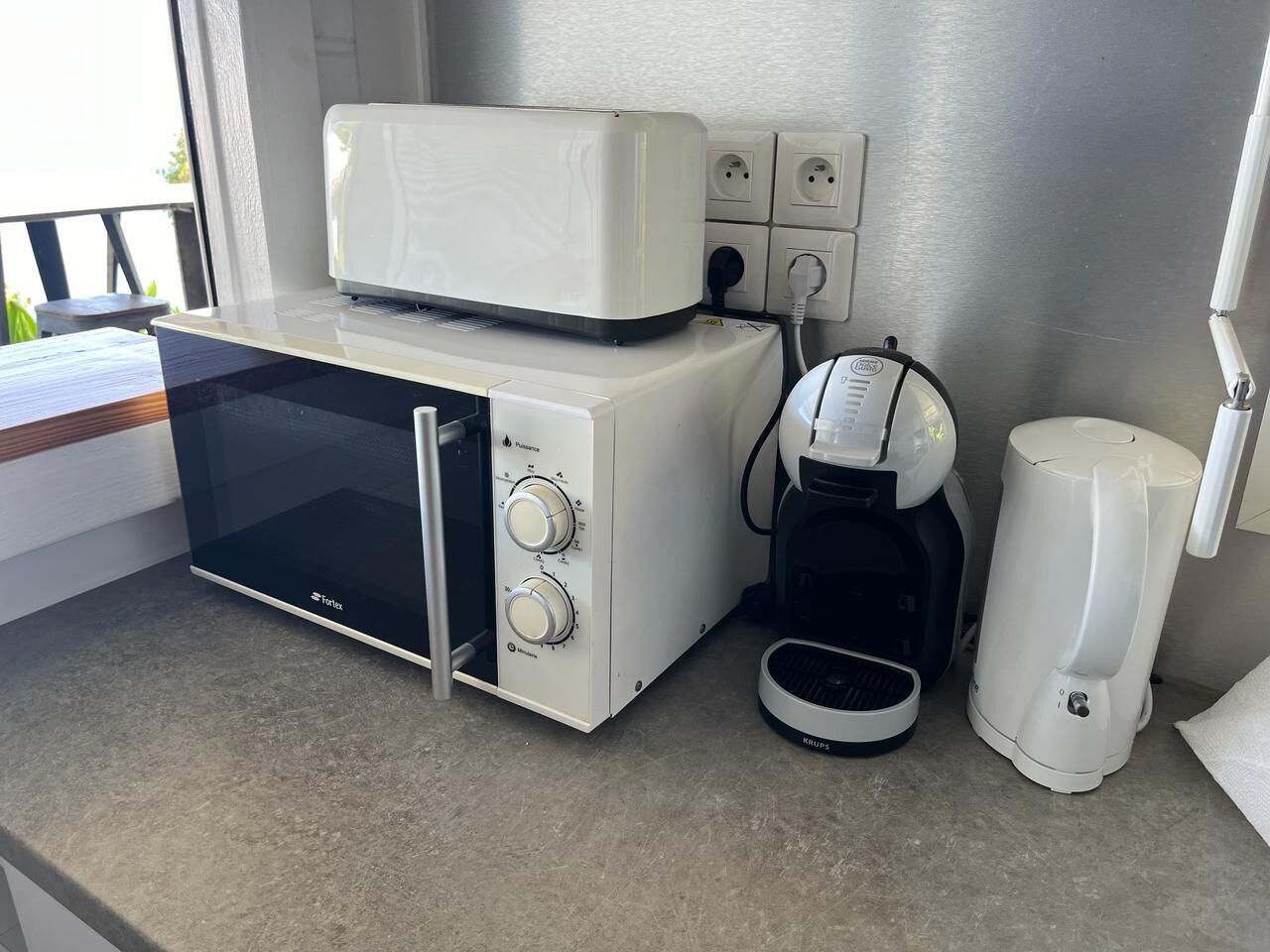 Une petite cuisine équipée d’un four à micro-ondes, d’une machine à café et d’un grille-pain.