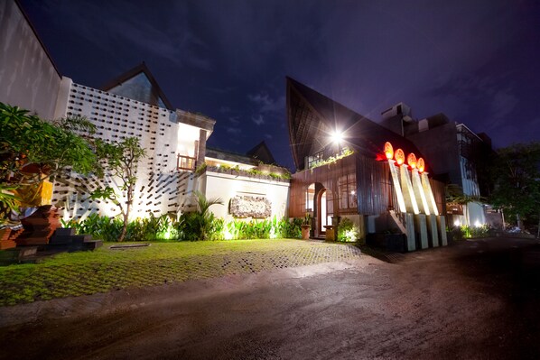 A modern building with a unique geometric facade, a paved entrance, and well-maintained greenery. - Kusuma Living and Villa Seminyak (Denpasar)