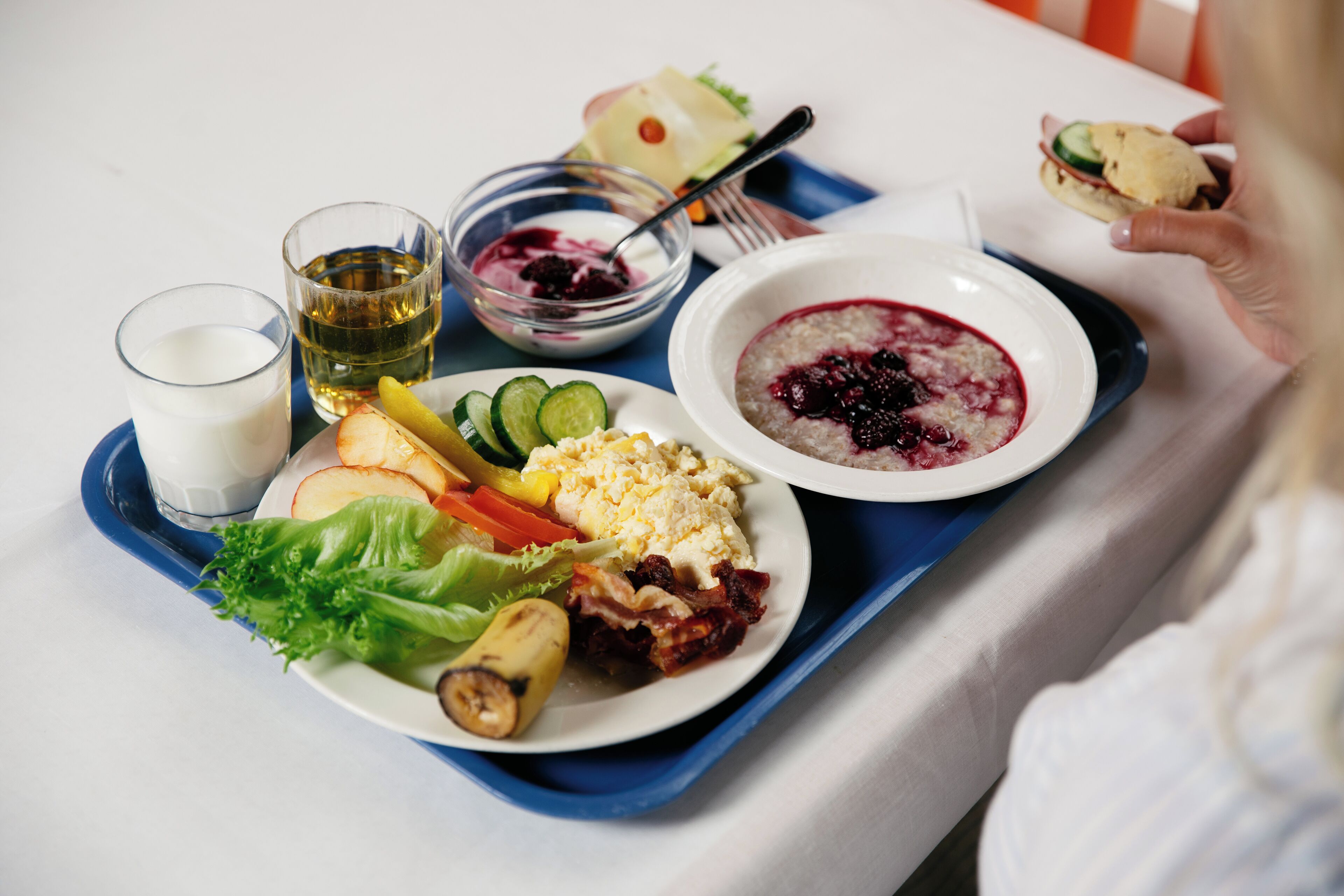 Ett bricka med olika sorters mat, inklusive en sallad, soppa och en smörgås.