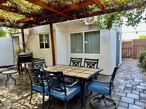 An outdoor patio with a table and chairs, a grill, and a pergola with vines. - A Family Home Get-Away! 4 BR 2 Bath & Private Yard! (San Diego)