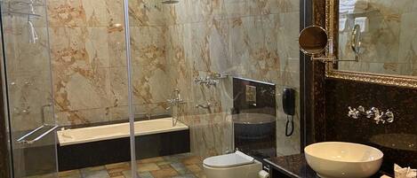 A modern bathroom with a glass-enclosed shower, a freestanding bathtub, a vanity with a large mirror, and a toilet.