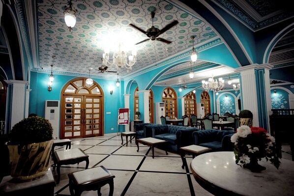A spacious lobby with a high ceiling, chandeliers, and a seating area with sofas and tables. - Umaid Farm Resort - A Legacy Vintage Stay in Jaipur (Jalsu)