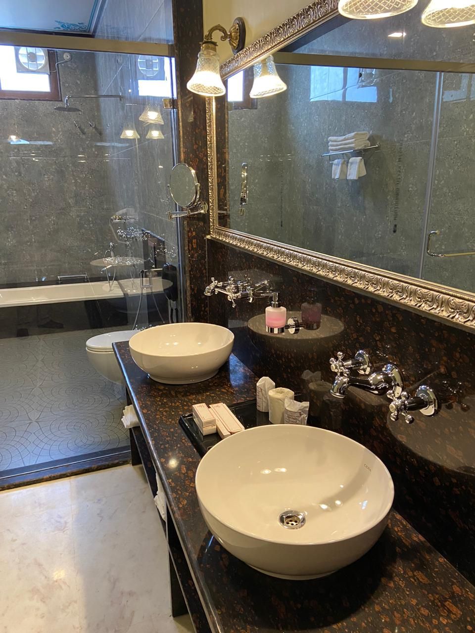 A modern bathroom with two large sinks, a mirror, and a bathtub.