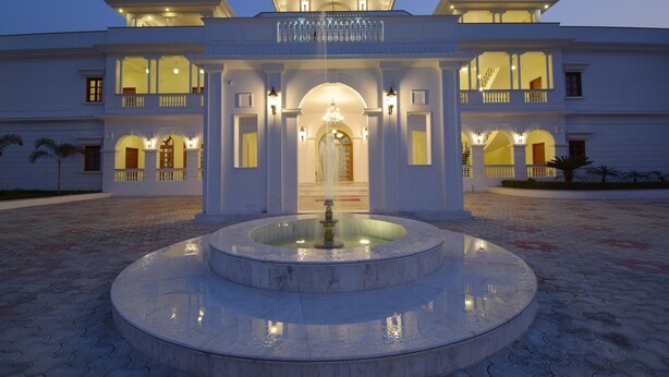 A grand building with a central fountain, multiple balconies, and a symmetrical facade.