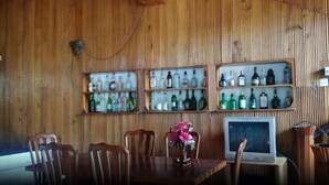 A wooden-paneled room with a dining table, chairs, and a television. - Dutch Villa (Galle)