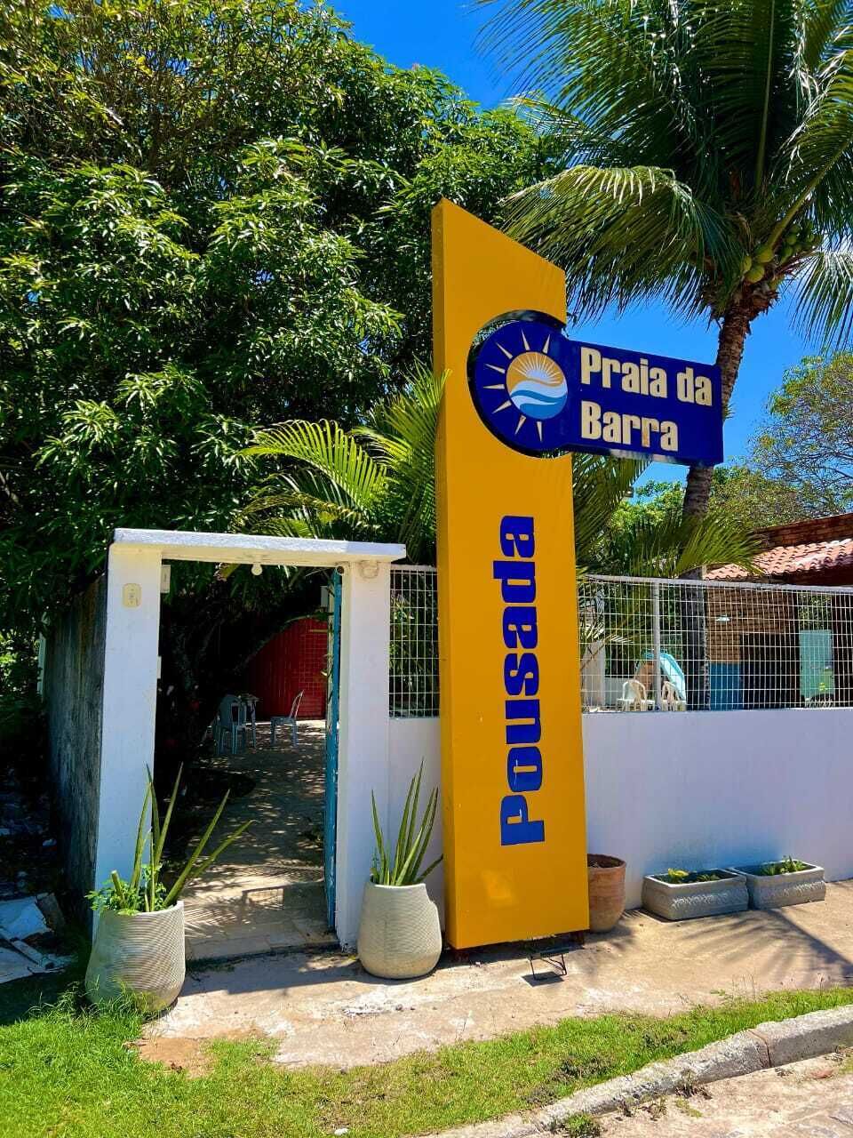 Segnaletica per Praia da Barra, con un motivo giallo e blu, un piccolo cancello d'ingresso e piante in vaso.