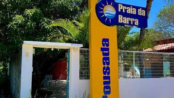 Segnaletica per Praia da Barra, con un motivo giallo e blu, un piccolo cancello d'ingresso e piante in vaso.