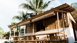 A traditional bamboo structure with a balcony, surrounded by palm trees. - Seaview Hills Luxury Apartments & Rooms (Dauis)