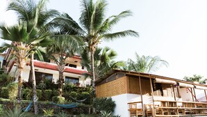 A resort with a large building, palm trees, and a hammock. - Seaview Hills Luxury Apartments & Rooms (Dauis)