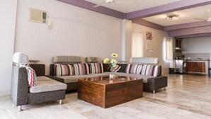 A living room with a sectional sofa, a coffee table, and a ceiling fan. - Seaview Hills Luxury Apartments & Rooms (Dauis)