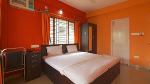 A bedroom with a bed, a desk, a chair, a wardrobe, and a window with curtains. - Bh Boutique Hotel (Baruipur)