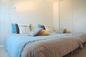 A bedroom with a bed, pillows, a bedside lamp, and a wardrobe.