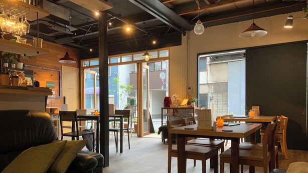 A cozy café with wooden furniture, a lit candle, and a view of the street outside. - Wabi Sabi Osaka (Osaka)