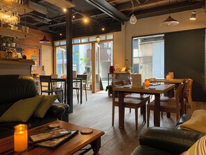 A cozy café with wooden furniture, a lit candle, and a view of the street outside.
