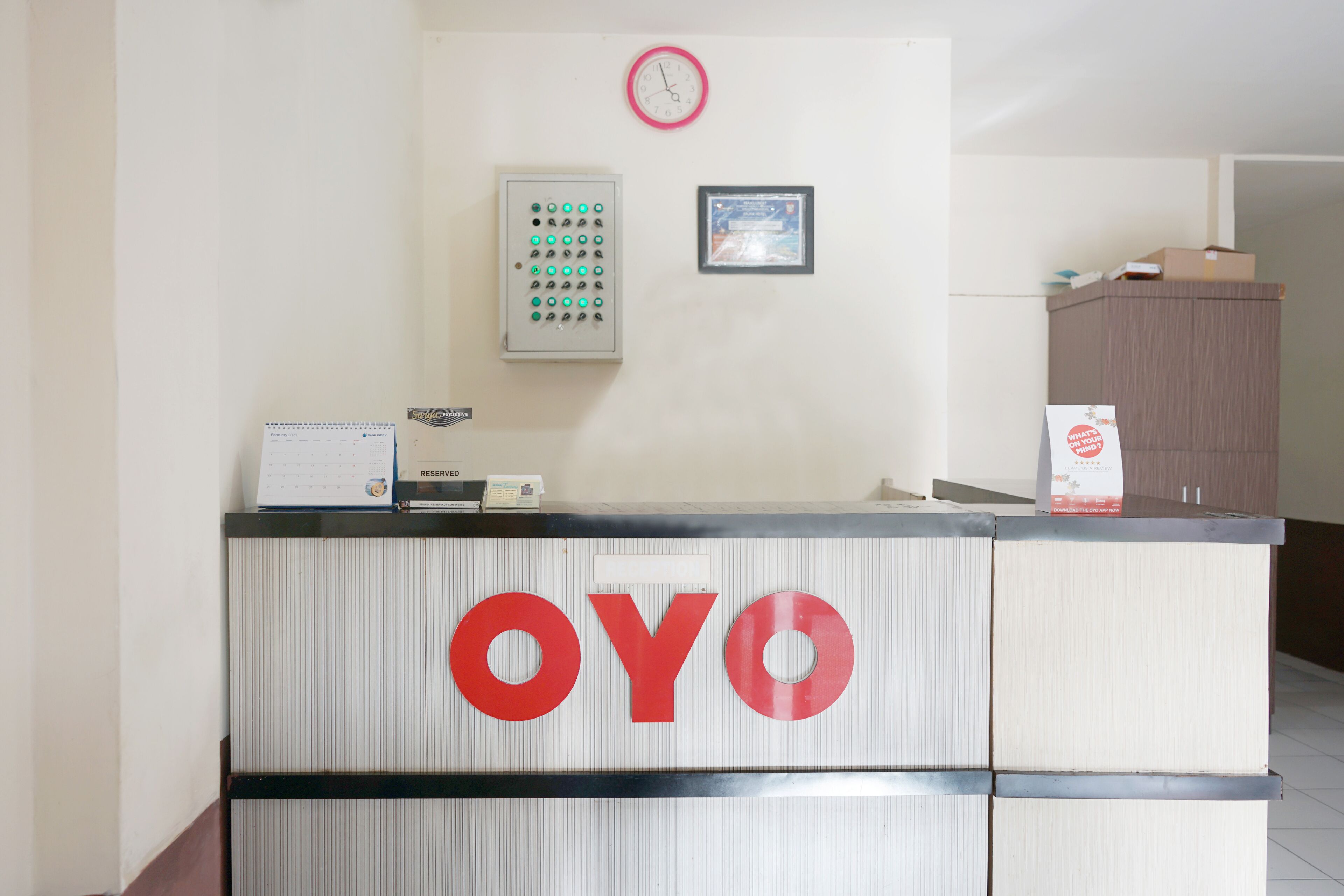A reception desk with a clock and a framed certificate on the wall.