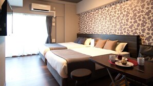 A hotel room with two beds, a table with a plate of food, and an air conditioning unit.