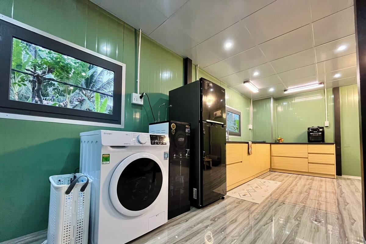 Un cuarto de lavado con lavadora, secadora y refrigerador.
