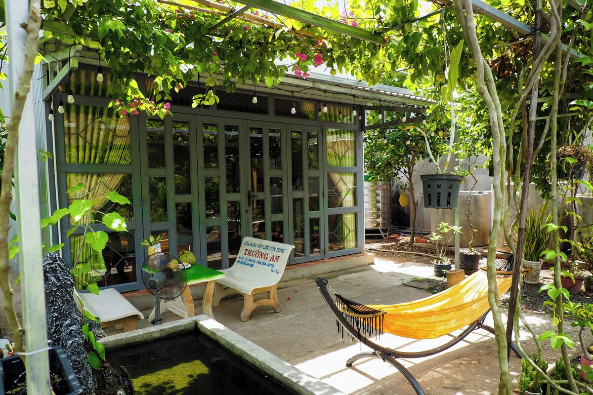 Un espacio de estar al aire libre cubierto con una hamaca, una mesa y un cartel.