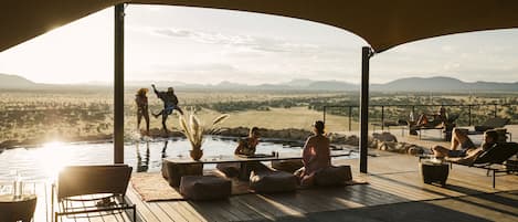 Una piscina al aire libre, sillones reclinables de piscina