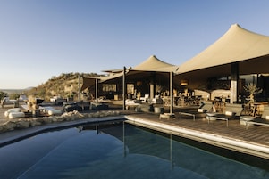 Una piscina al aire libre, tumbonas