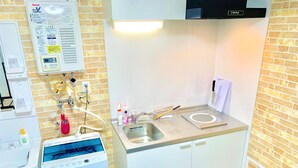 Una cocina con un lavamanos, lavadora y dispensador de agua.