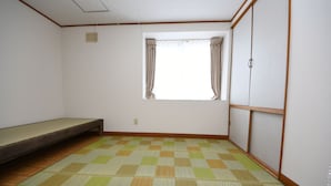 A room with a checkered floor, a window with curtains, a wardrobe, and a bench.