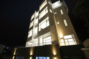 Un edificio a più piani con finestre e balconi illuminati di notte.
