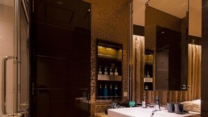 A modern bathroom with a large mirror, a sink, and a shower area. - Hotel Glanz Cascata (Tokyo)