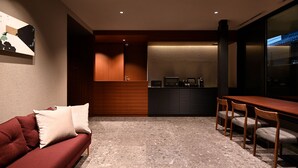 A modern interior with a red sofa, wooden dining table, and chairs. - HOTEL KYOTOLOGY (Kyoto)
