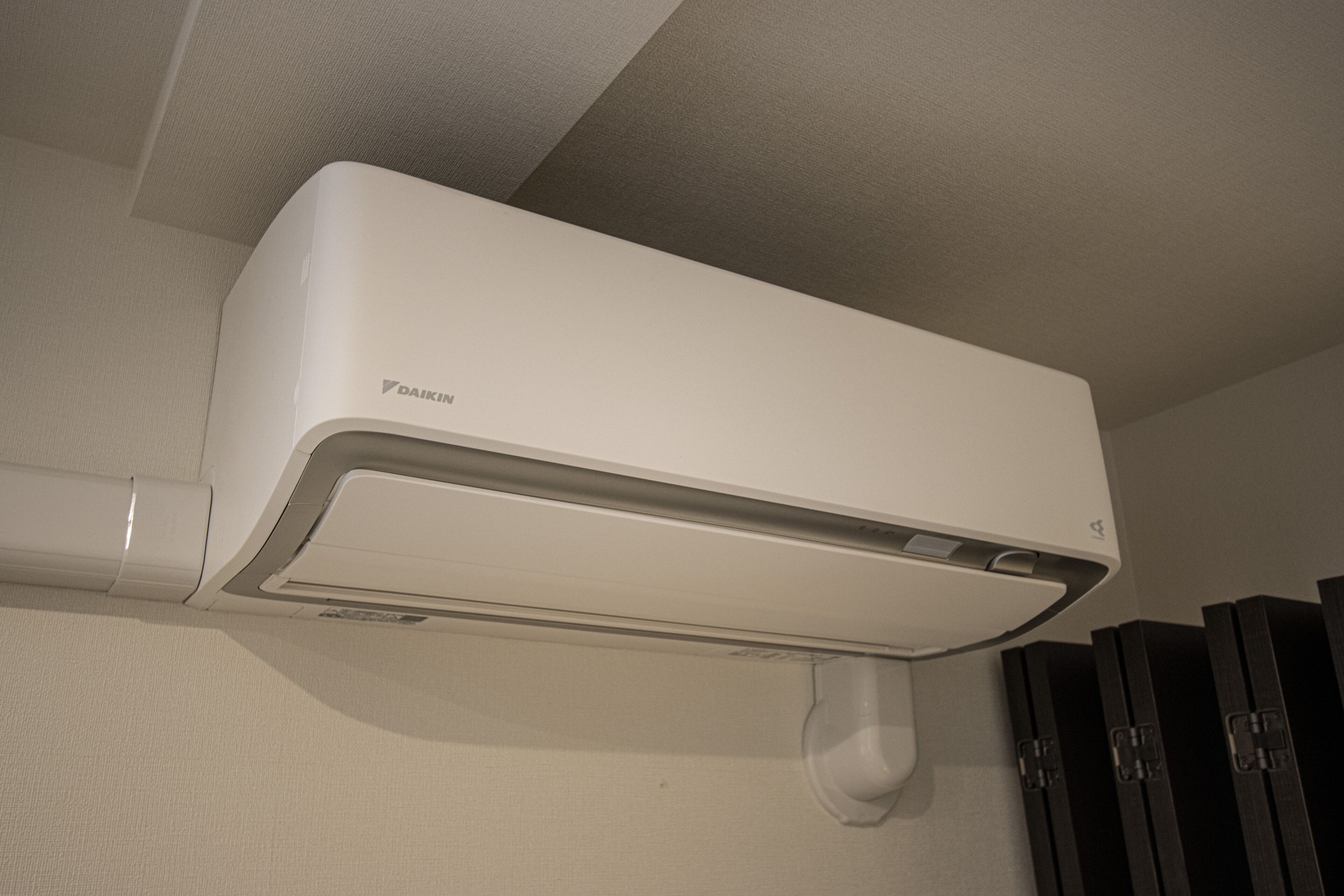 A white Daikin air conditioner unit mounted on a wall.