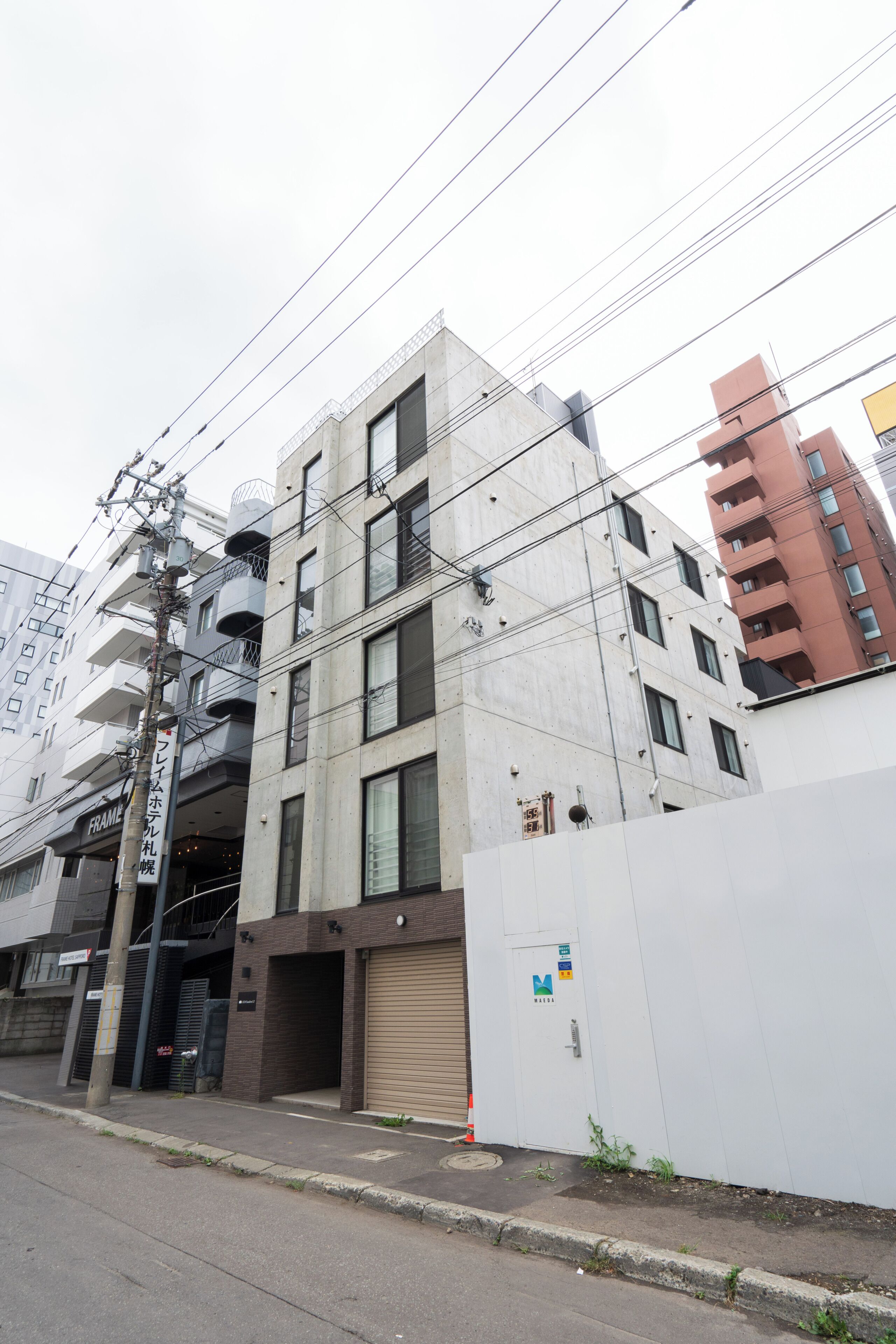 A multi-story building with a garage door, a utility pole, and power lines.