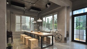 A spacious kitchen with a large island, wooden stools, and a bicycle in the background. - Genuinn (Taitung)