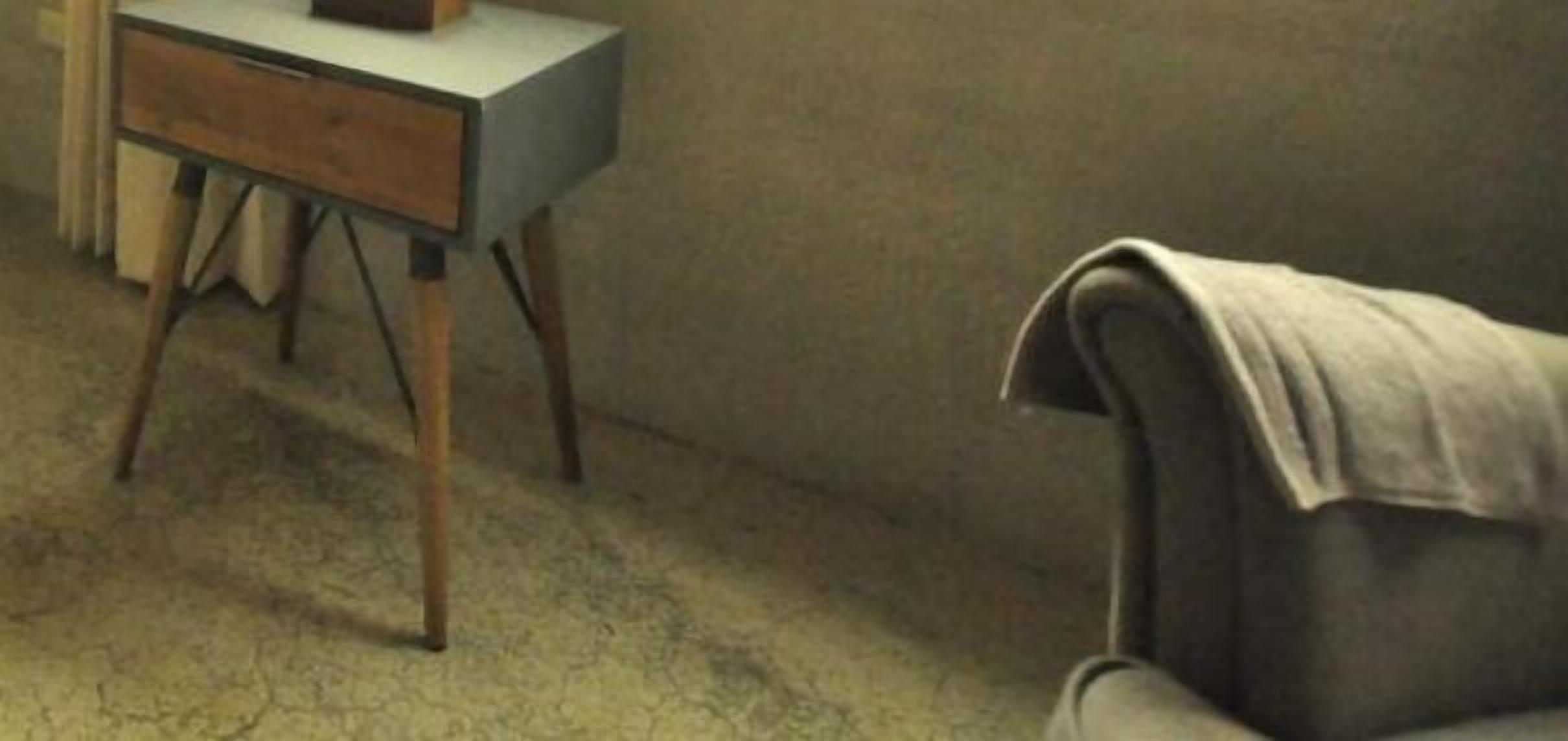 A room with a desk, a chair, and a plain wall.