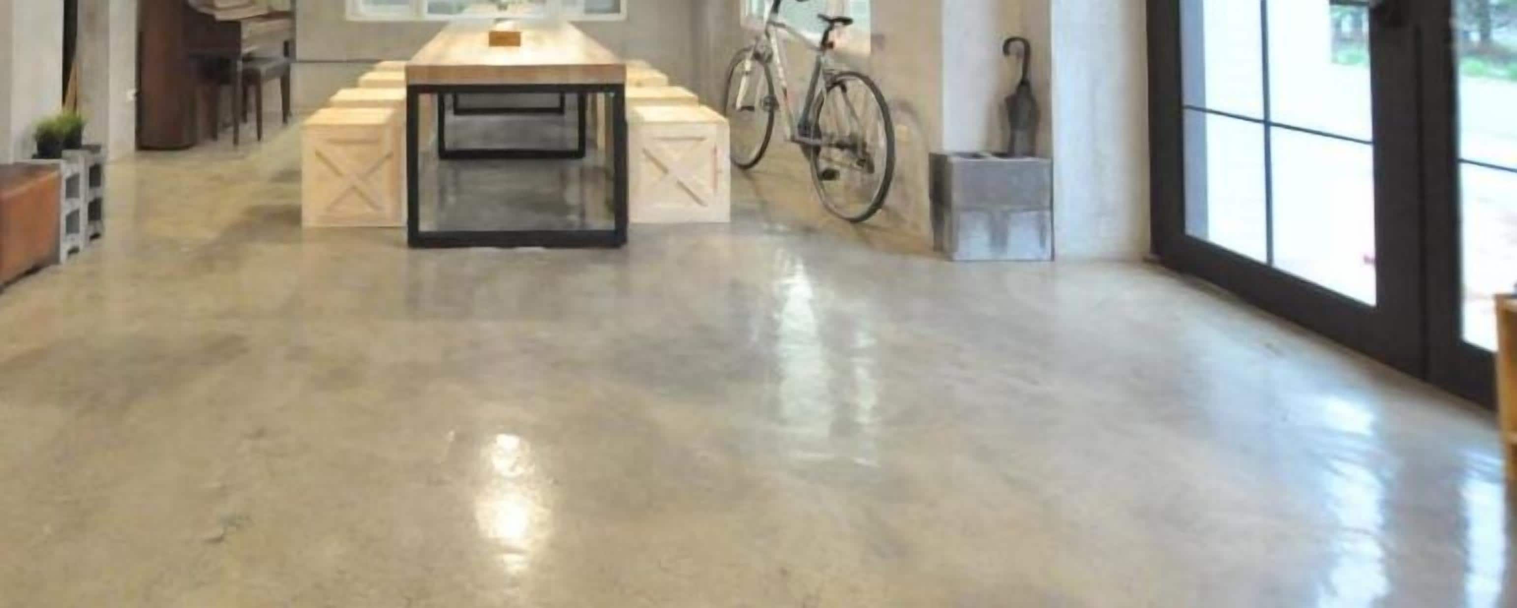 Una habitación amplia con una mesa grande, una bicicleta y una ventana con vistas.