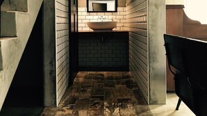 A narrow bathroom with a large mirror, a vessel sink, and a tiled floor. - Genuinn (Taitung)