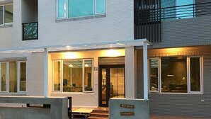 A modern building with a covered entrance, large windows, and a sign indicating a business or office space. - Genuinn (Taitung)