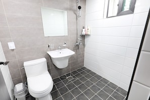 A modern bathroom with a toilet, sink, and shower.