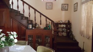 A staircase with wooden balusters leading to a landing with a china cabinet.