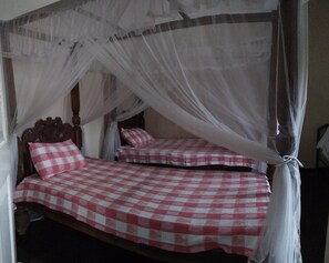 A room with a four-poster bed and a canopy bed.