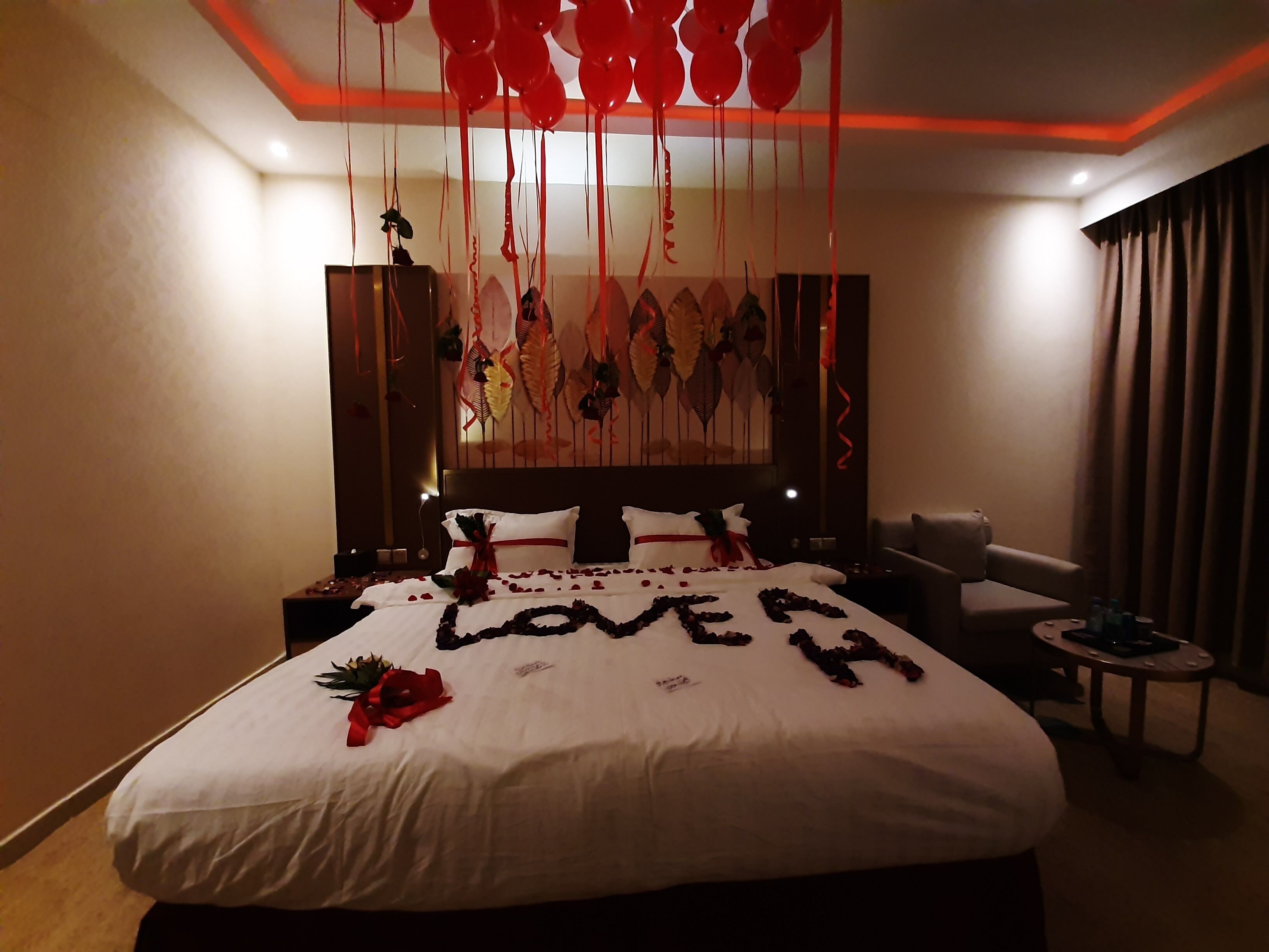 A hotel room with a bed, a nightstand, a chair, and a small table.