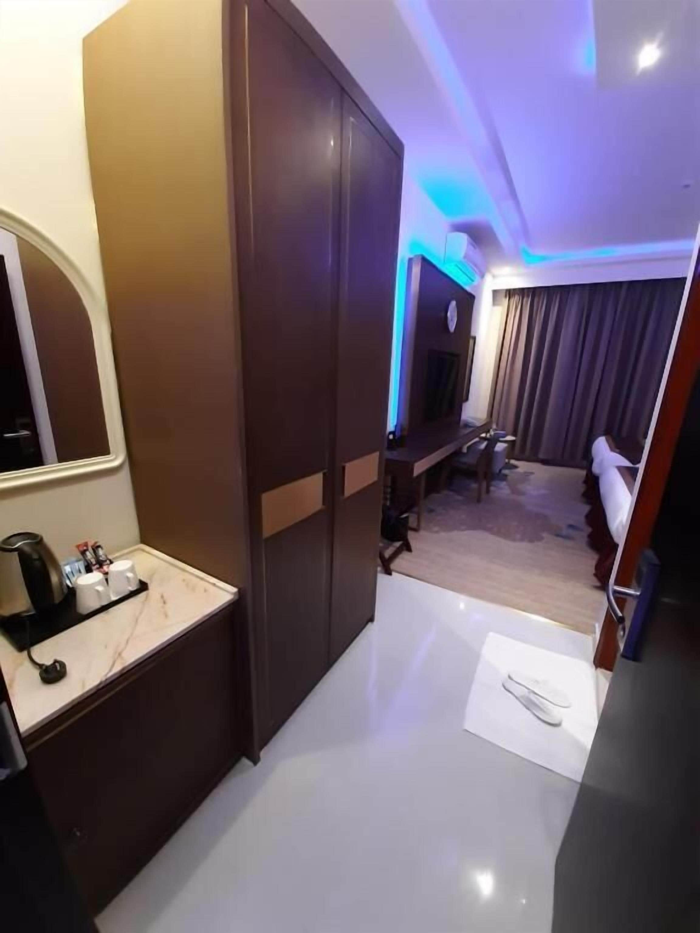 Habitación de hotel con encimera de mármol, cafetera y televisión.