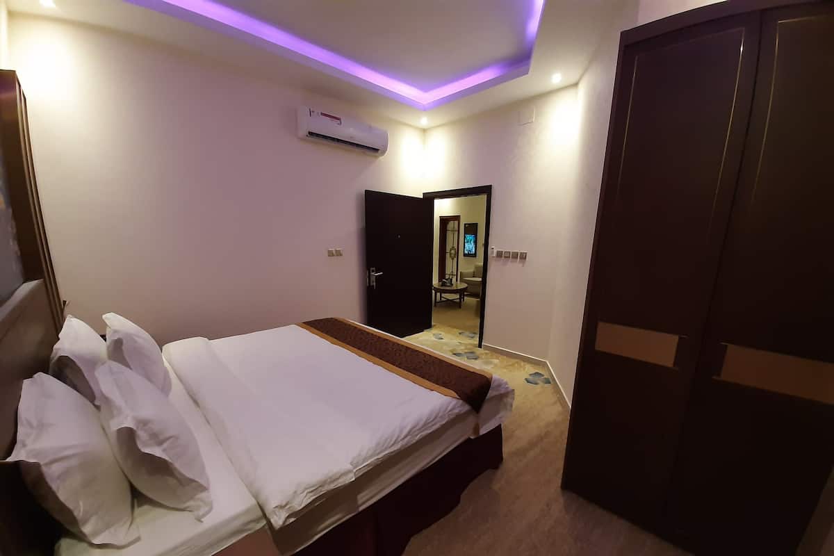 Een hotelkamer met een bed, een kledingkast, een airconditioning en een spiegel.