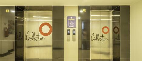 An elevator with metallic doors and a sign indicating floor levels.