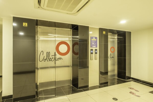 Um elevador com uma placa indicando 'Collection' e um logótipo circular na parede.