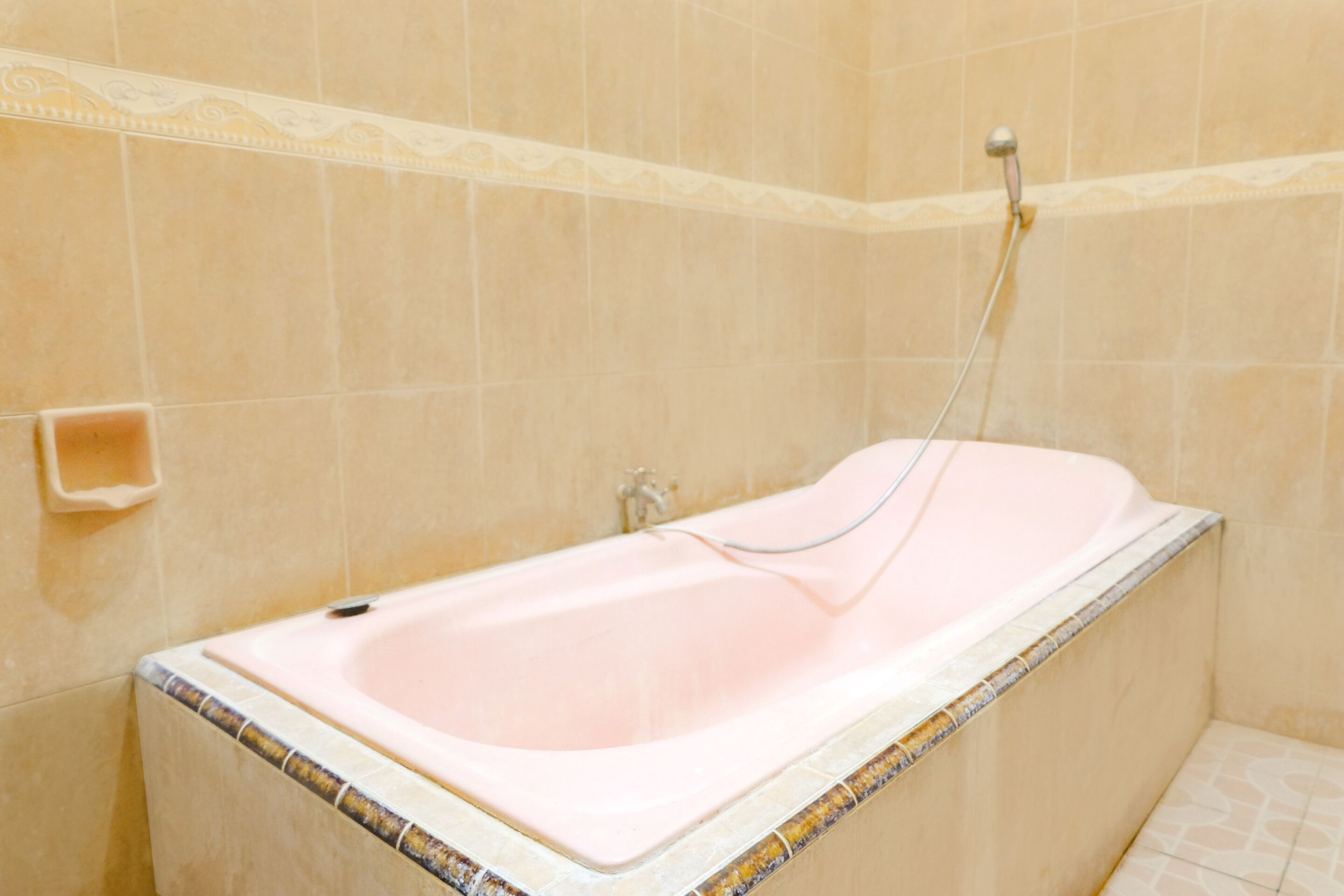 A bathroom with a bathtub, a shower, and a tiled wall.