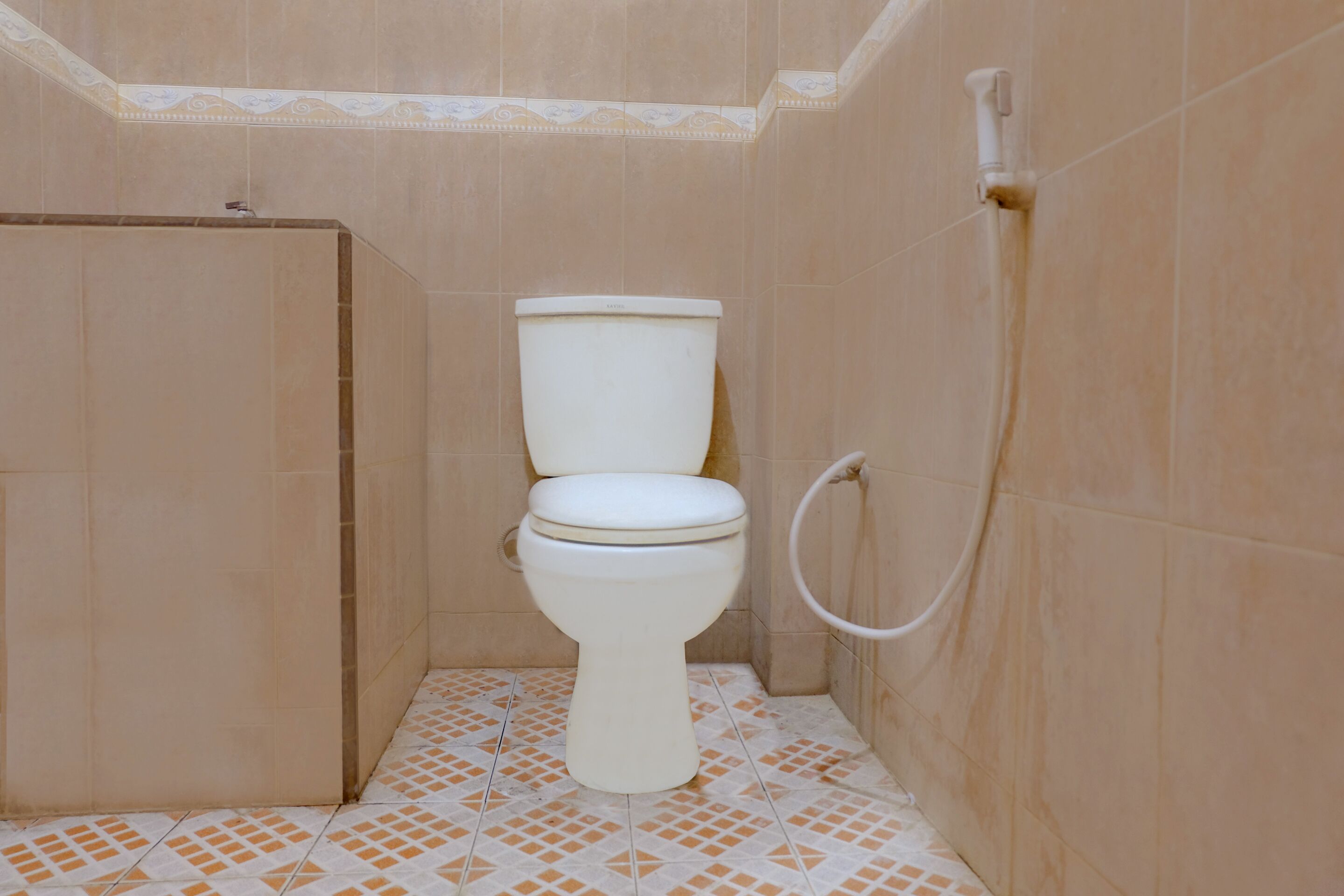 Un baño pequeño con azulejos, un inodoro, una cabina de ducha y un dispensador de papel higiénico.